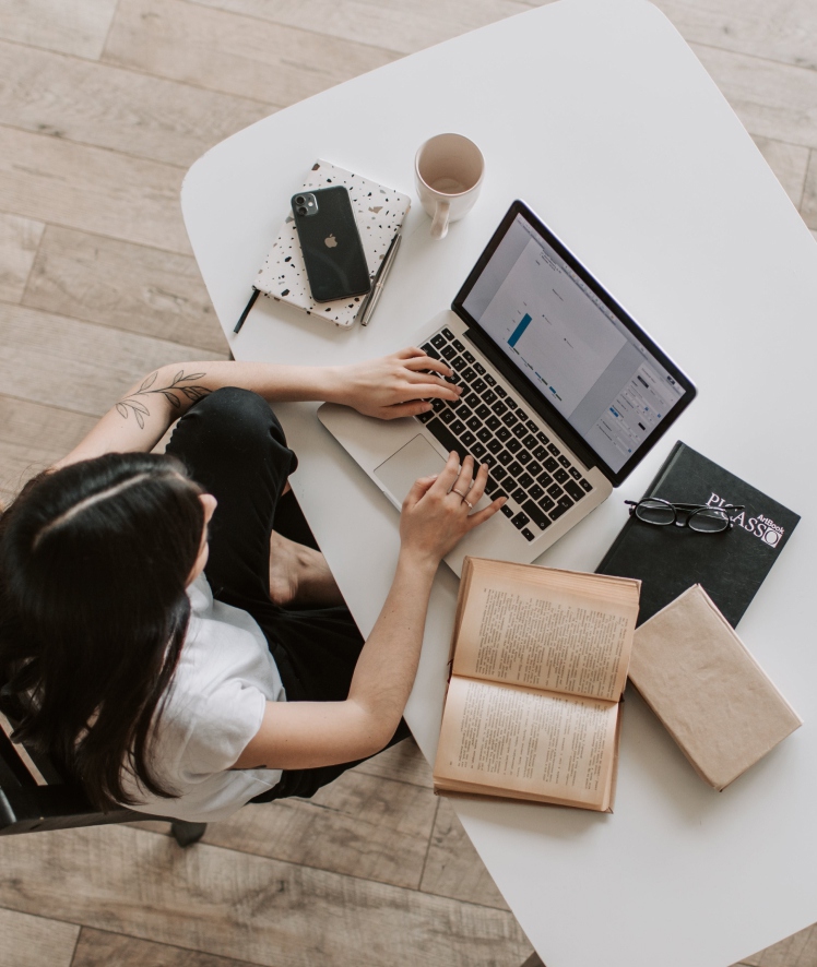 A woman working with a laptop and papers