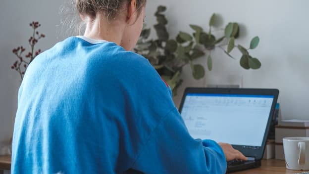 A woman working on a computer at home